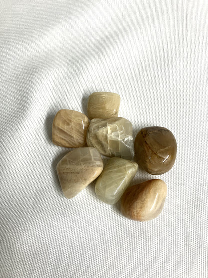 Tumbled Moonstone Crystals on a white fabric background