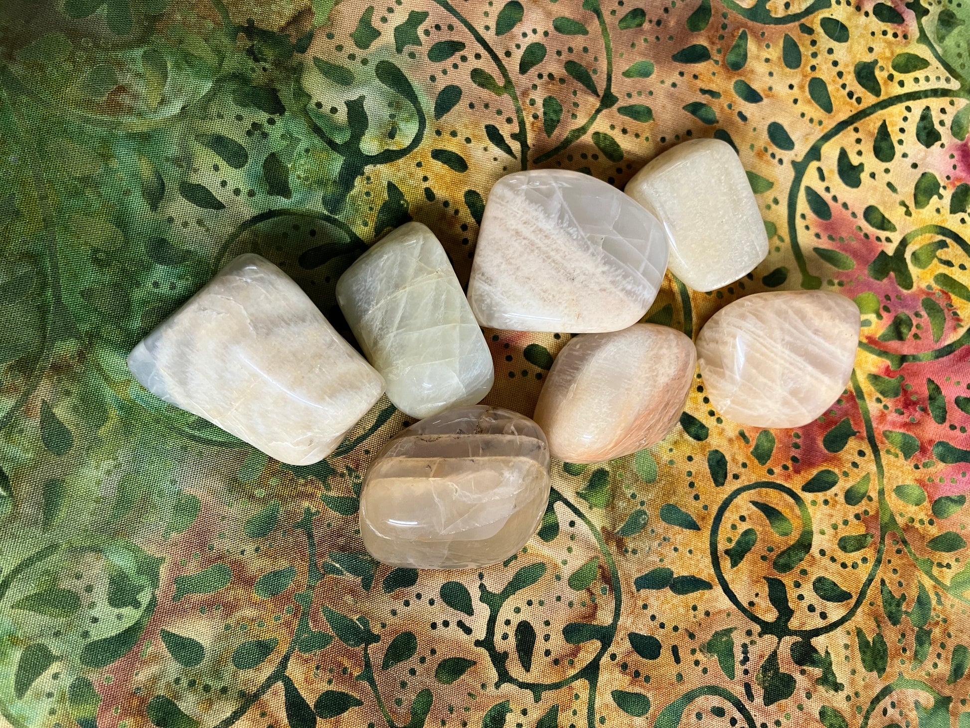Front view of Moonstone Crystals on a decorative fabric background