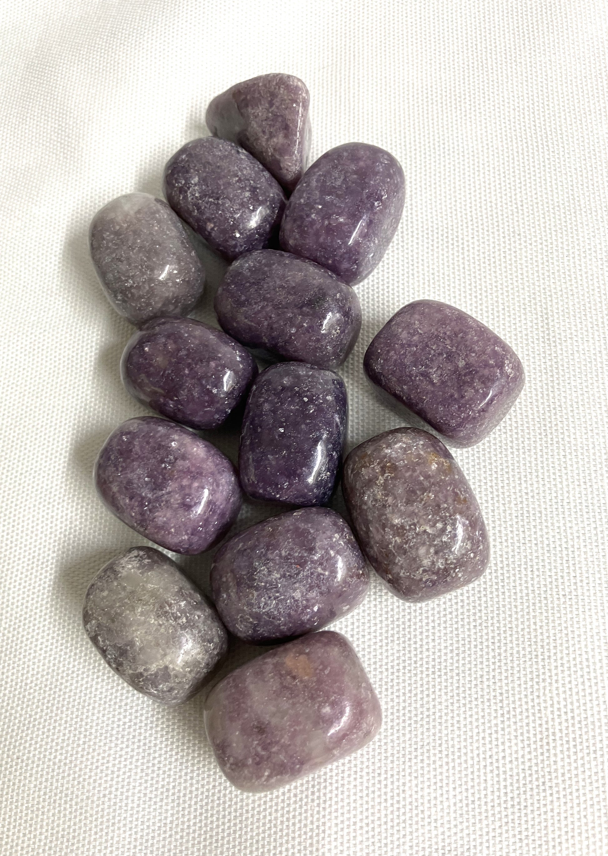 Front side of Lepidolite Crystals on a white fabric background
