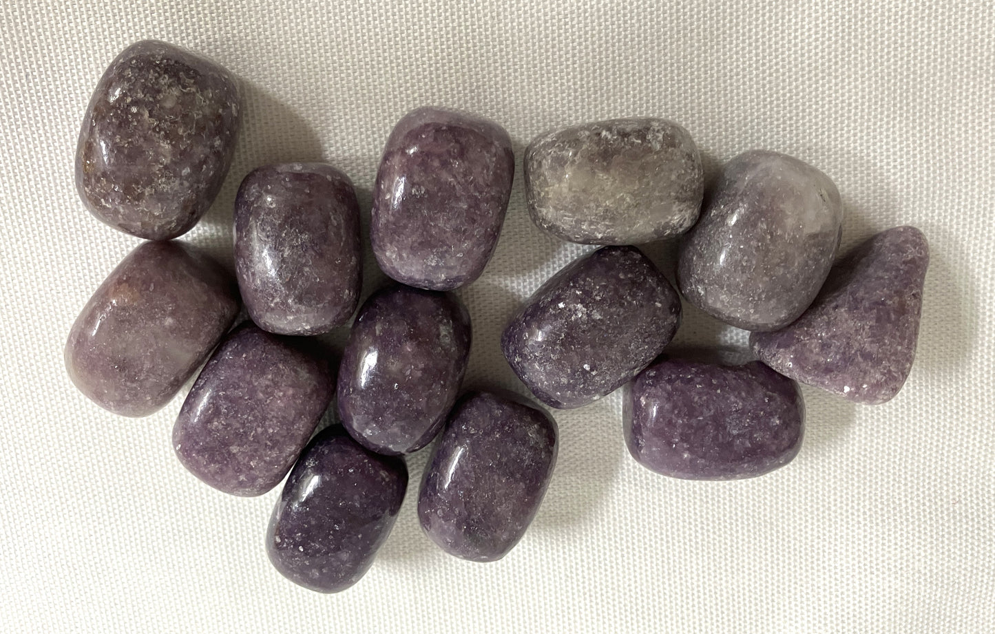 Lepidolite Crystals shown on a white fabric background