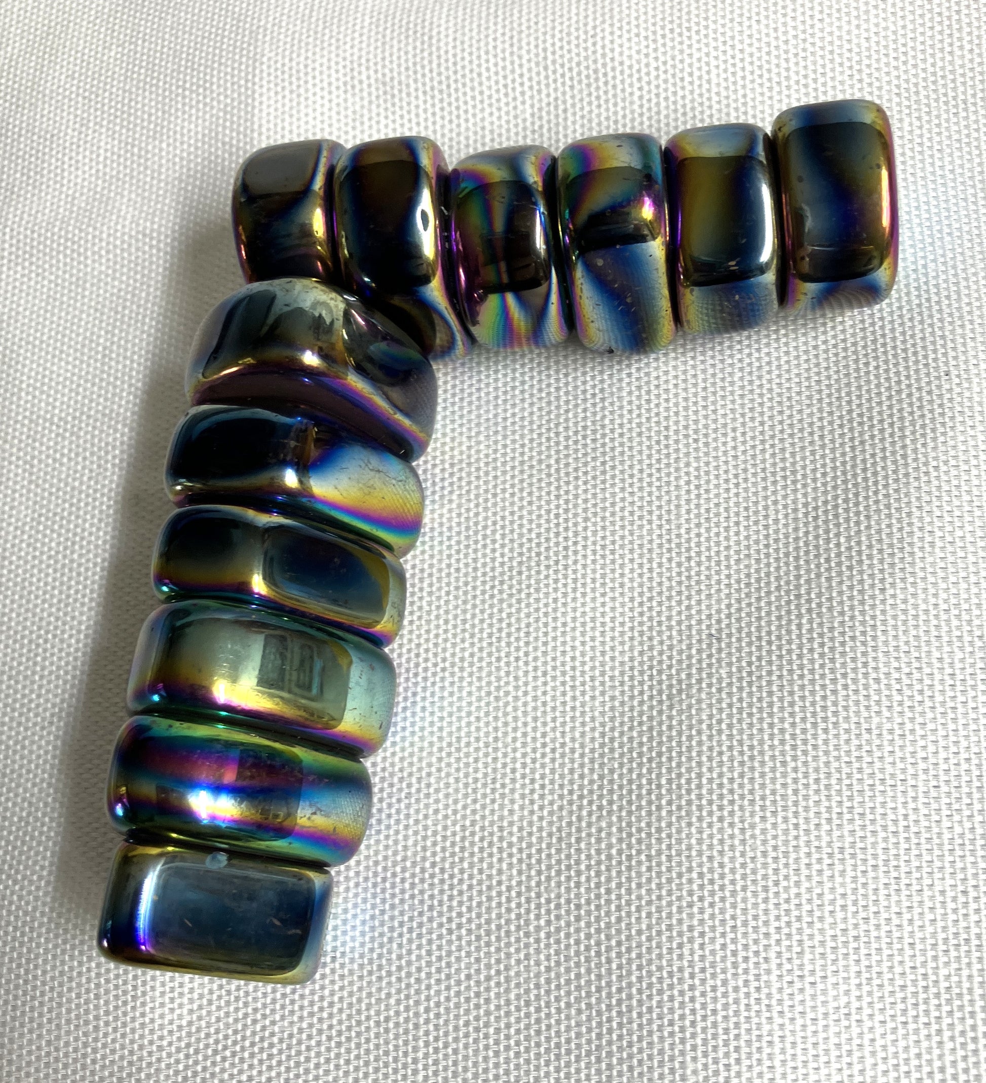 Magnetic Rainbow Hematite Crystals on a light fabric background