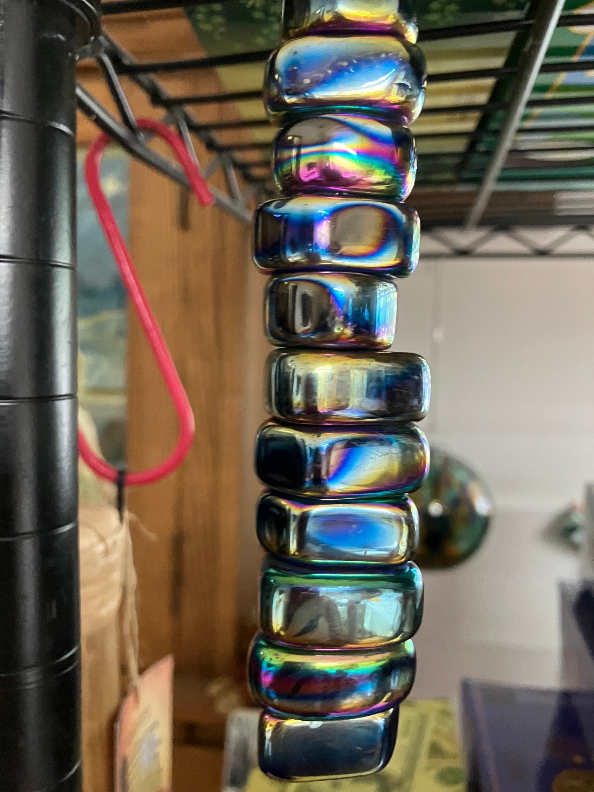 Magnetic Rainbow Hematite Crystals hanging from a  shelf with a blurred background