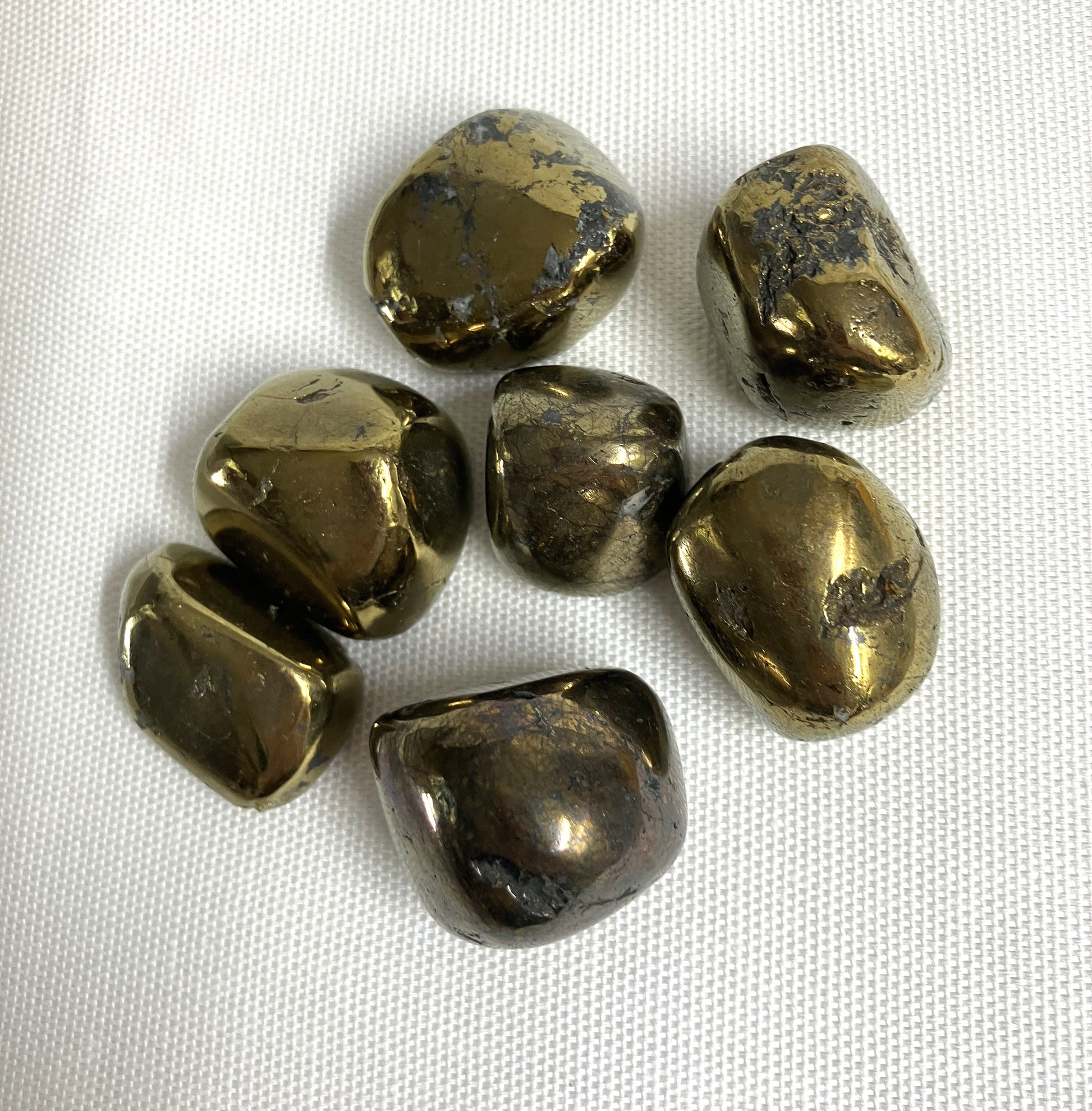 Peacock Ore Crystals AKA Chalcopyrite on a white fabric background