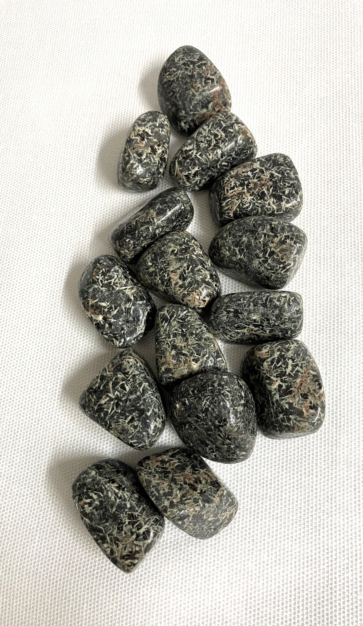 Tumbled Christmas Flower Jasper Crystals  on a white fabric background