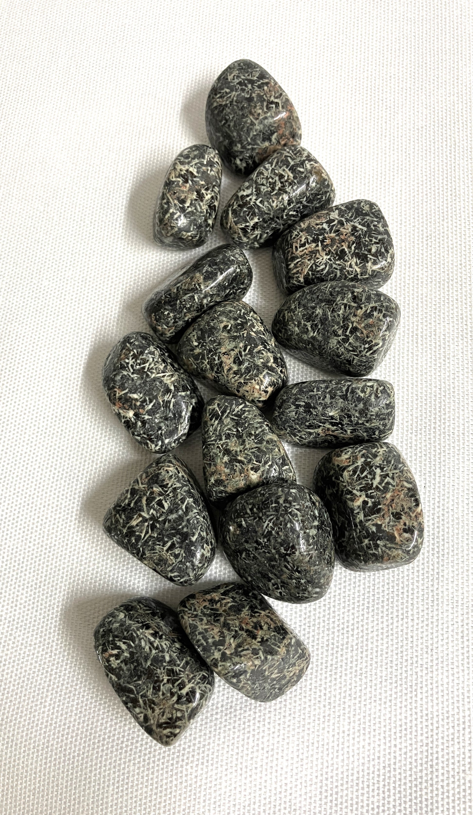 Tumbled Christmas Flower Jasper Crystals  on a white fabric background