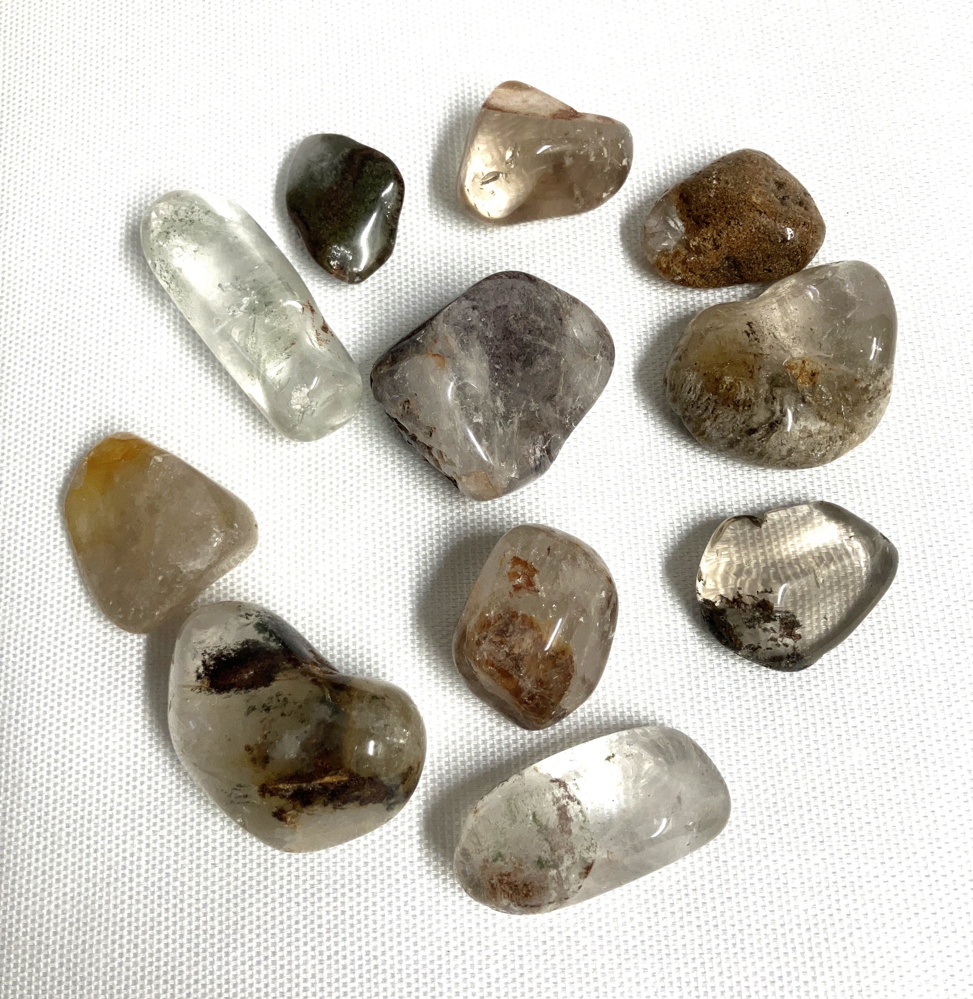 Front view of Lodolite Crystals AKA Garden Quartz on a white fabric background