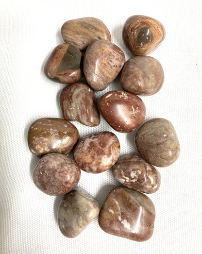 Assorted Crazy Lace Agate Crystals on a white fabric background