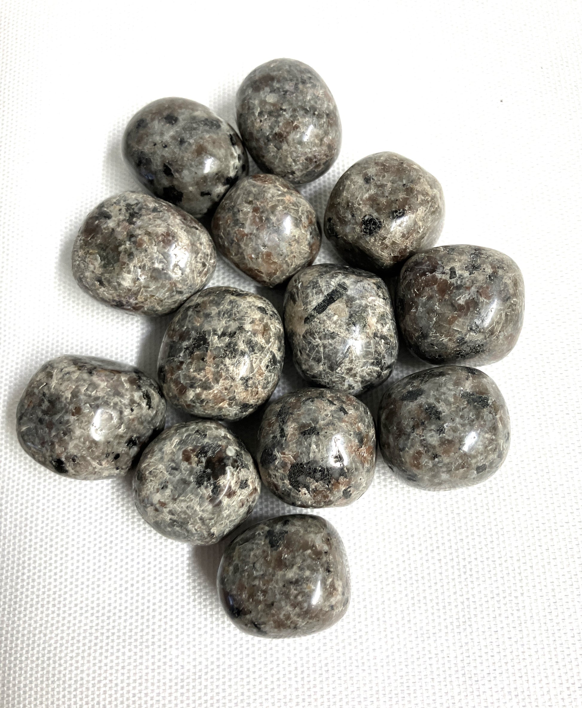 Natural light view of Flame Crystal AKA Yooperlite  on a white fabric background