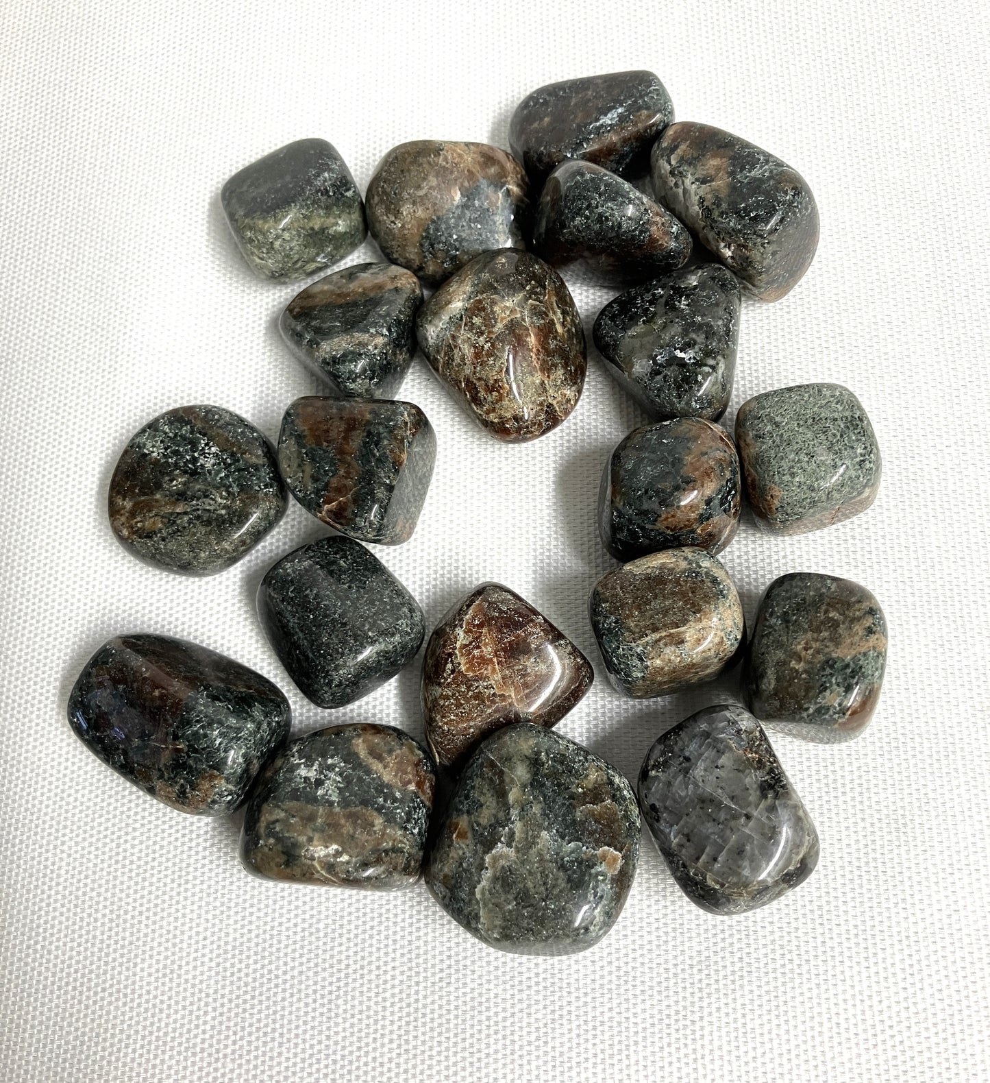 Green Garnet Crystals showing patterns and color on a white fabric background