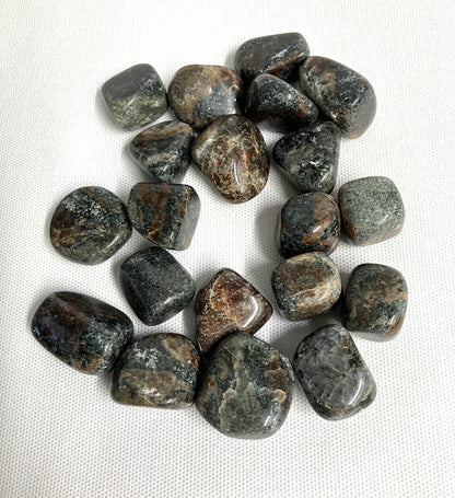 Green Garnet Crystals showing patterns and color on a white fabric background