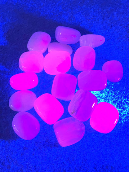 Tumbled Pink Calcite Crystals  on a blue background