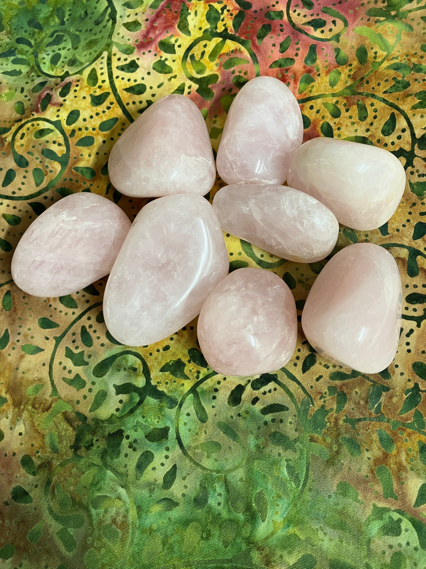 Closeup of Rose Quartz Crystals on a textured green and yellow surface