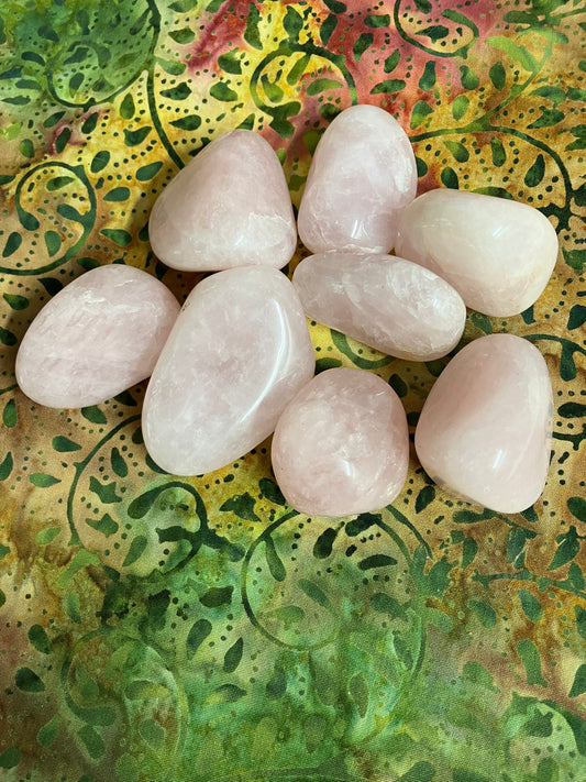 Closeup of Rose Quartz Crystals on a textured green and yellow surface