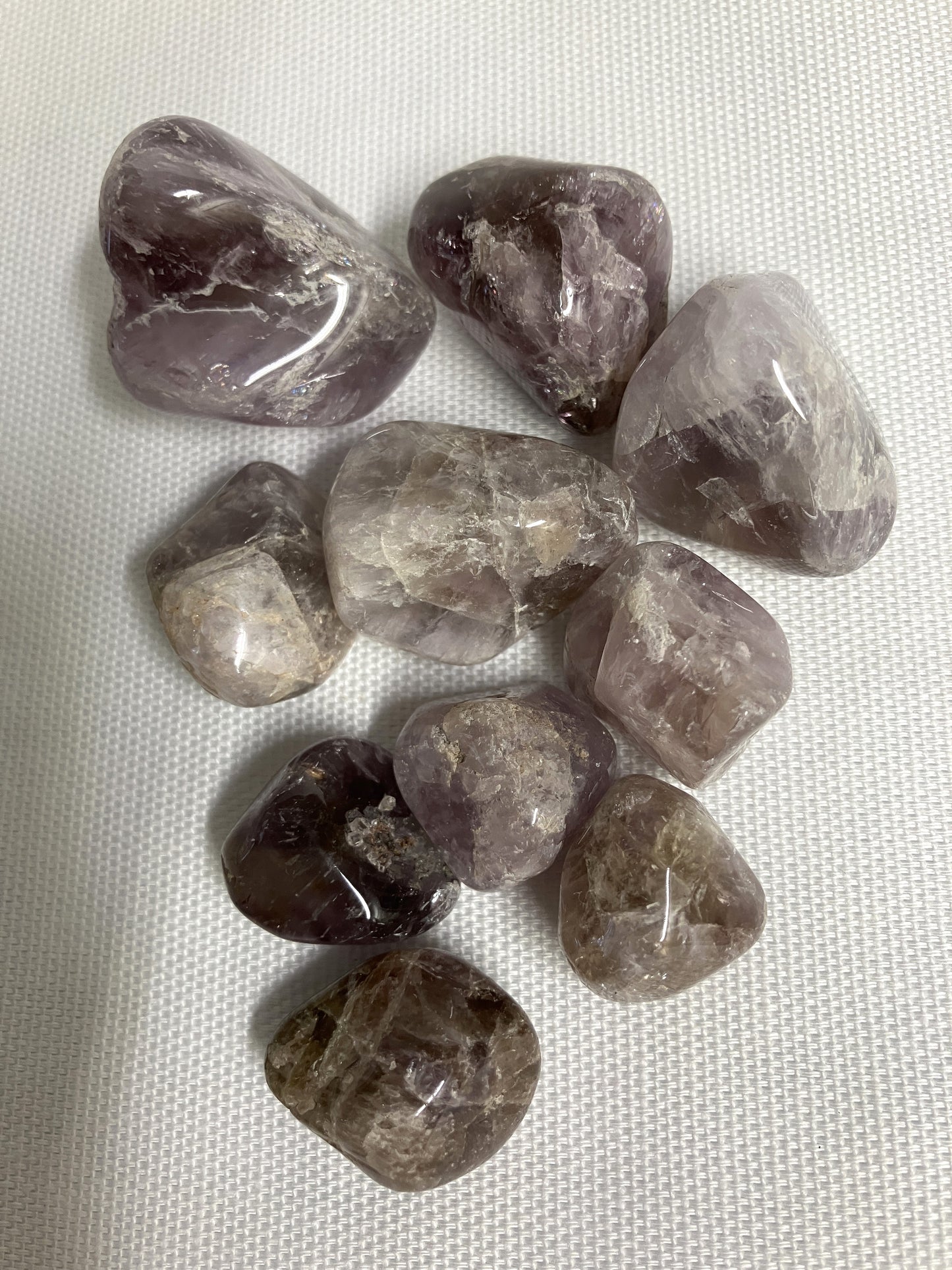 Closeup of Super Seven Crystals aka Melody's Stone on a white fabric background