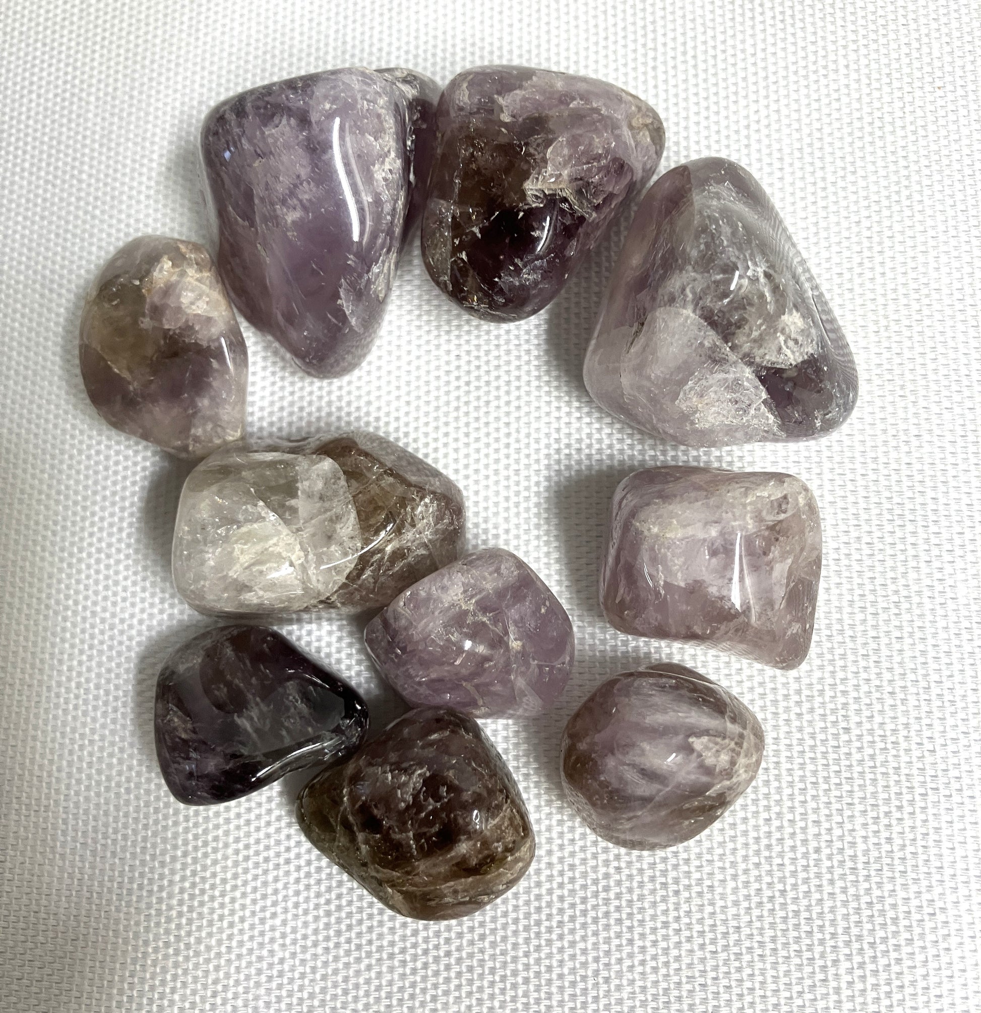 A grouping of Super Seven Crystals aka Melody's Stone on a white fabric background