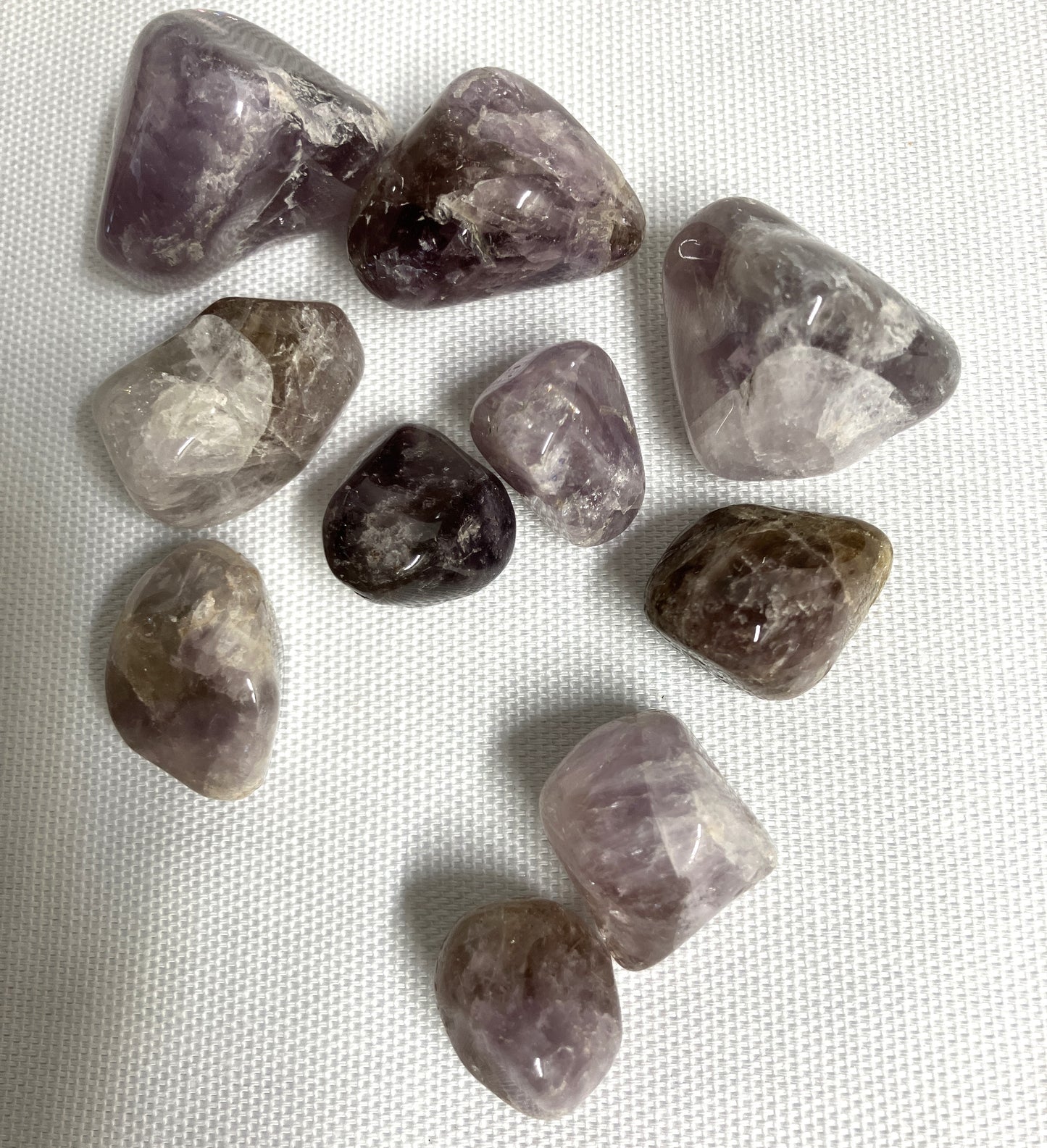 Collection of Super Seven Crystals aka Melody's Stone on a white fabric background