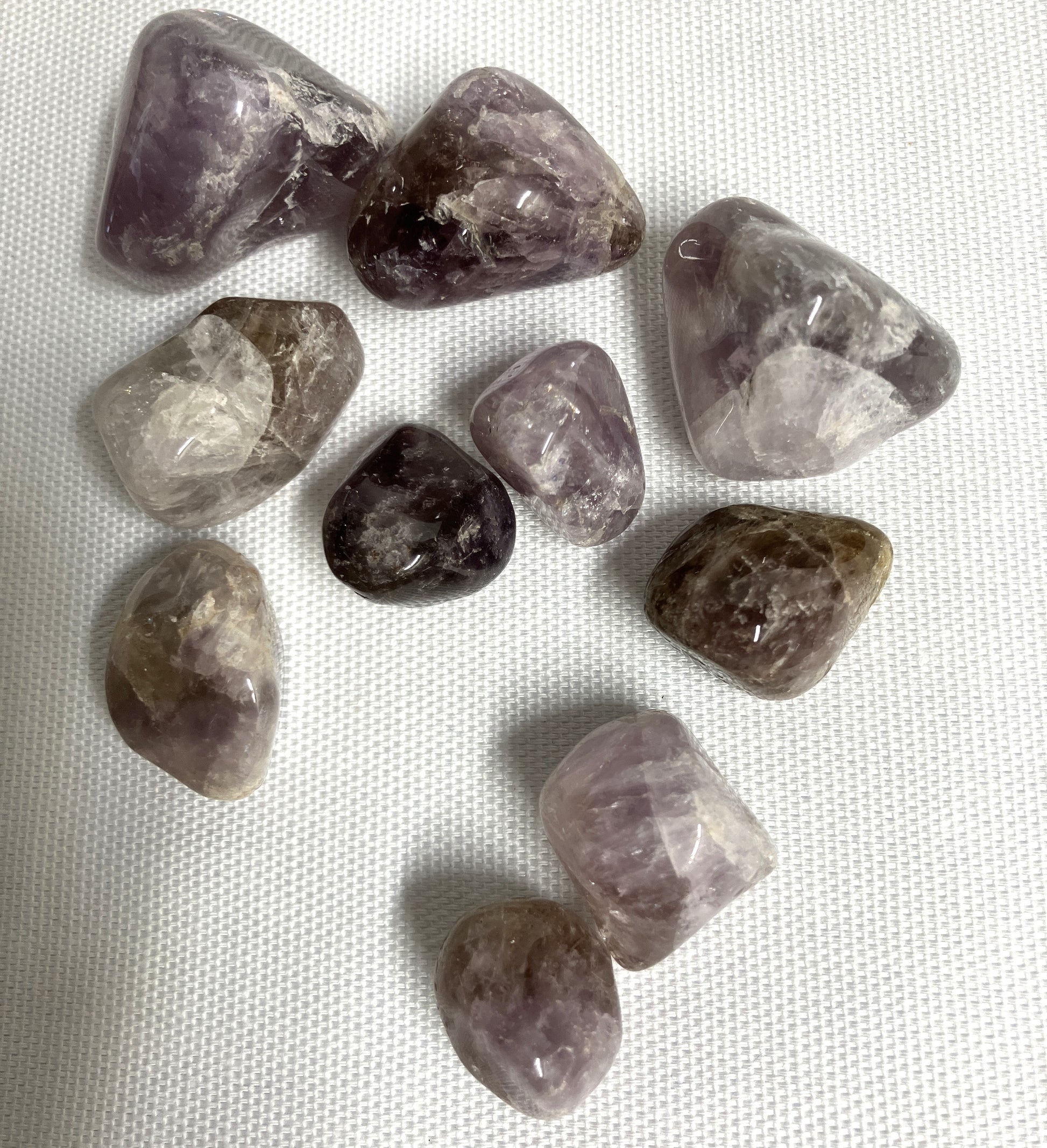 Collection of Super Seven Crystals aka Melody's Stone on a white fabric background