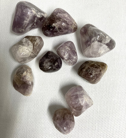 Collection of Super Seven Crystals aka Melody's Stone on a white fabric background