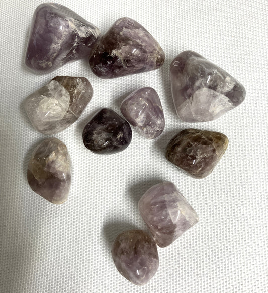 Collection of Super Seven Crystals aka Melody's Stone on a white fabric background