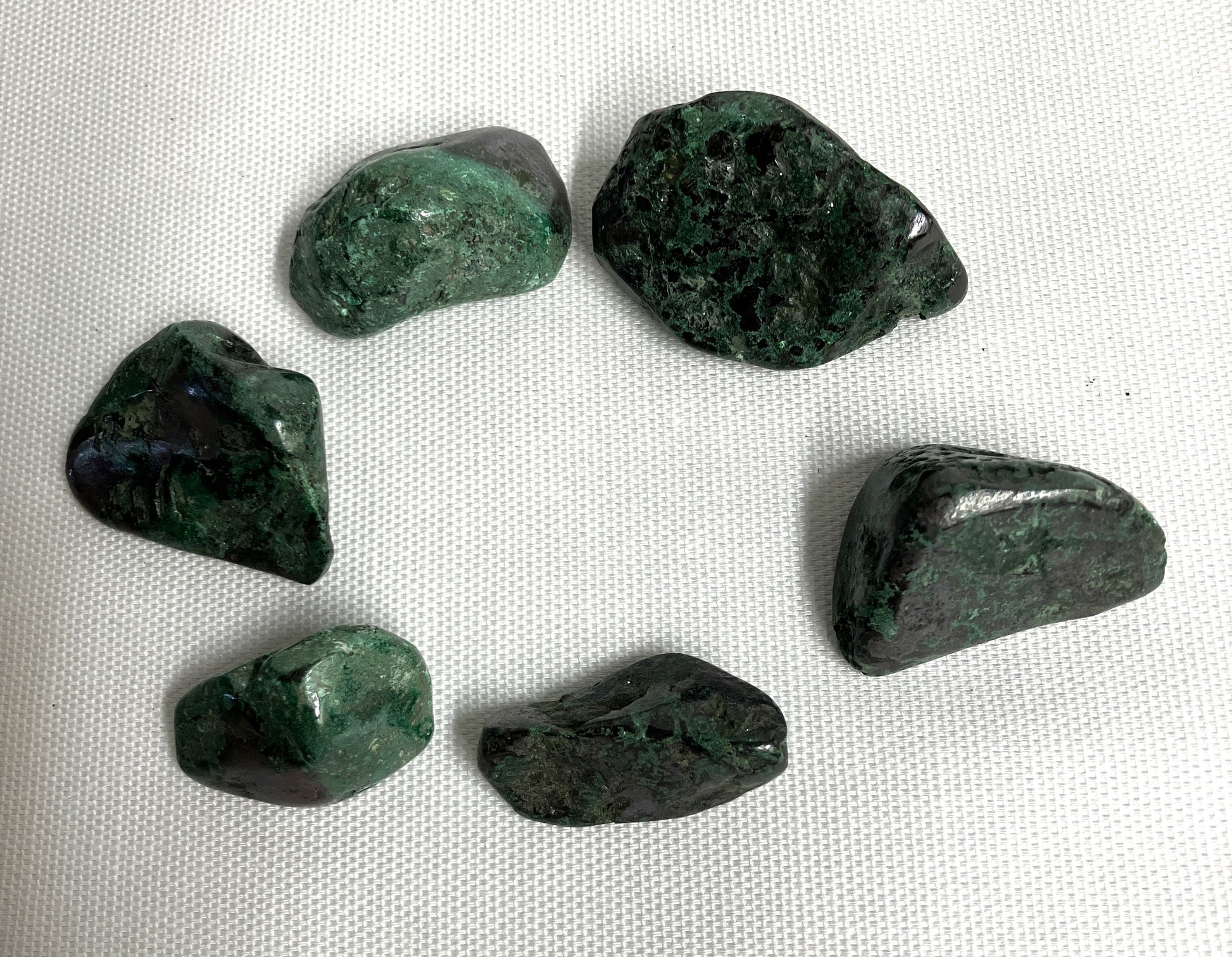 Six Cuprite Crystals showing the difference in color and pattern on a white fabric background