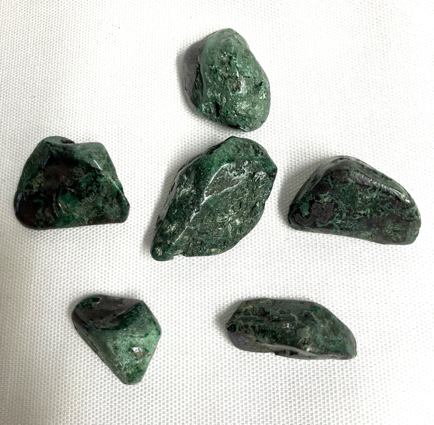 Six Cuprite Crystals on a white fabric background