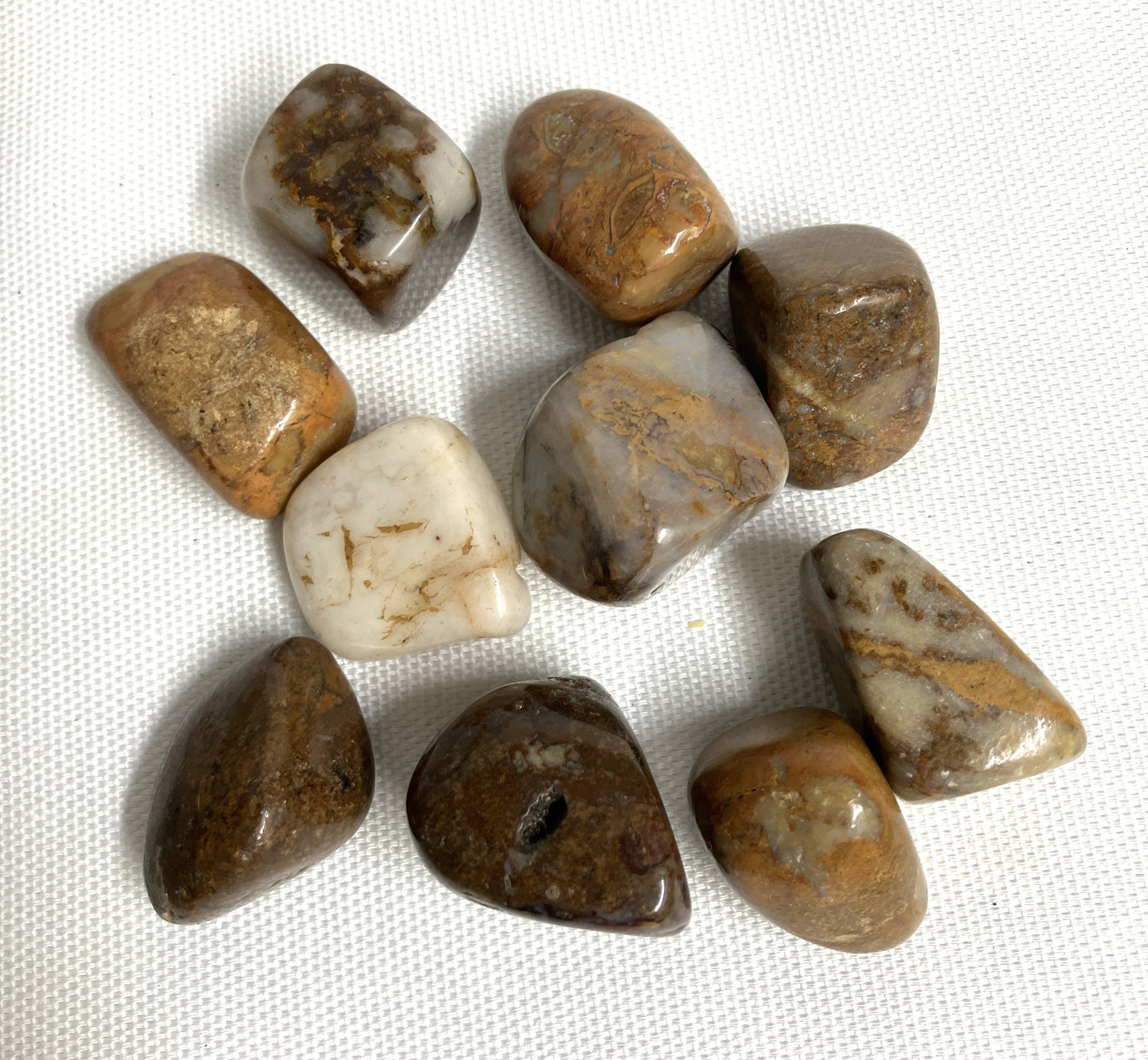 Tumbled Pietersite Crystal AKA The Tempest Stone  on a white fabric backgrounded