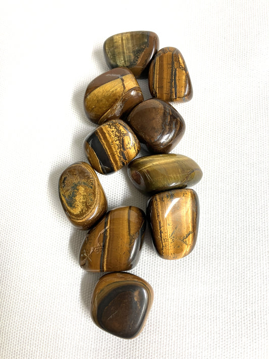 Collection of Yellow Tiger's Eye Crystals on a white fabric background