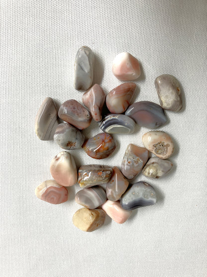 Collection of Botswana Agate Crystals showing the different patterns and colors on a light fabric background