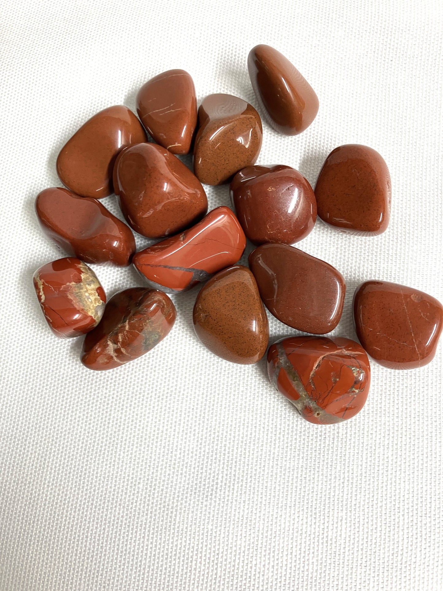 Red Jasper Crystals showing the back side on a white fabric background