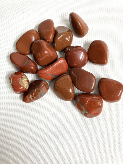 Red Jasper Crystals showing the back side on a white fabric background