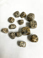 Tumbled Dalmatian Jasper Crystals on a white fabric background