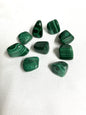 Green malachite stones on a white fabric background