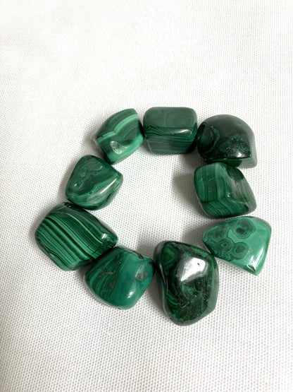 Malachite Crystals showing different patters on a white fabric background