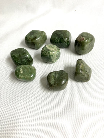 Back view of Grossularite Crystal aka Green Garnet on a white fabric background