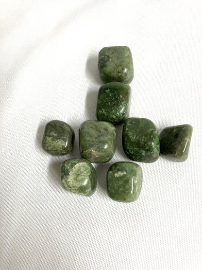 Front view of Grossularite Crystal aka Green Garnet on a white fabric background