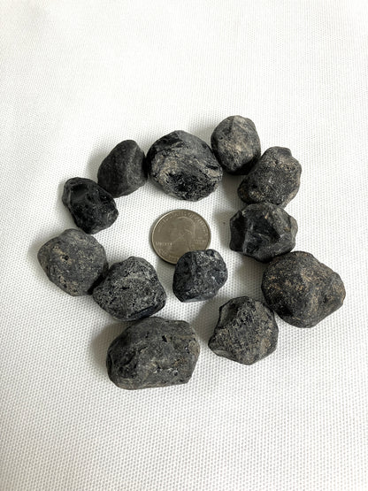 Rough Apache Tears stones on a white fabric background