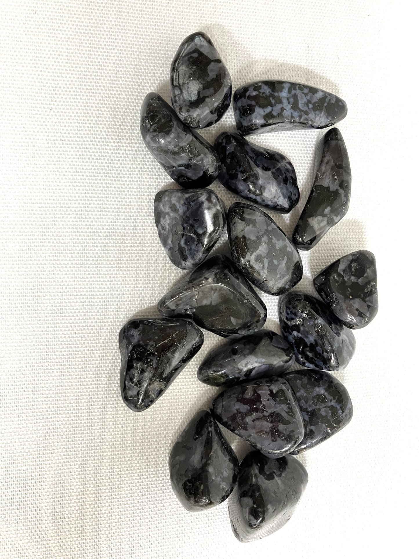 Indigo Gabbro Tumbled Crystals on a white fabric background