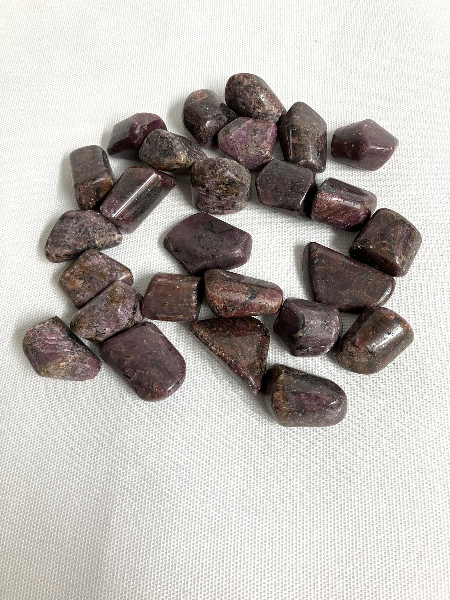 Showing the front side of Ruby Crystals on a white fabric background