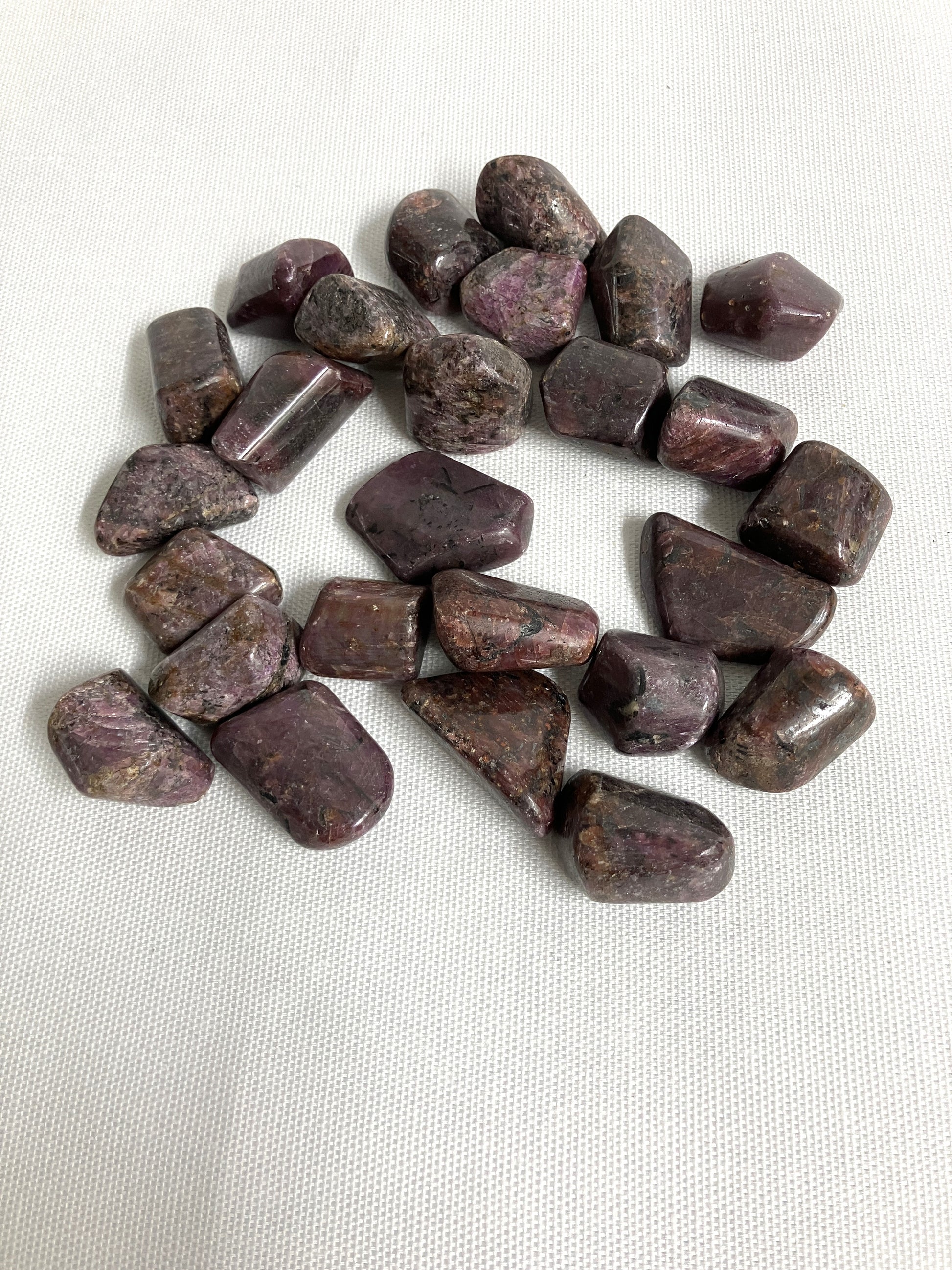 Showing the front side of Ruby Crystals on a white fabric background