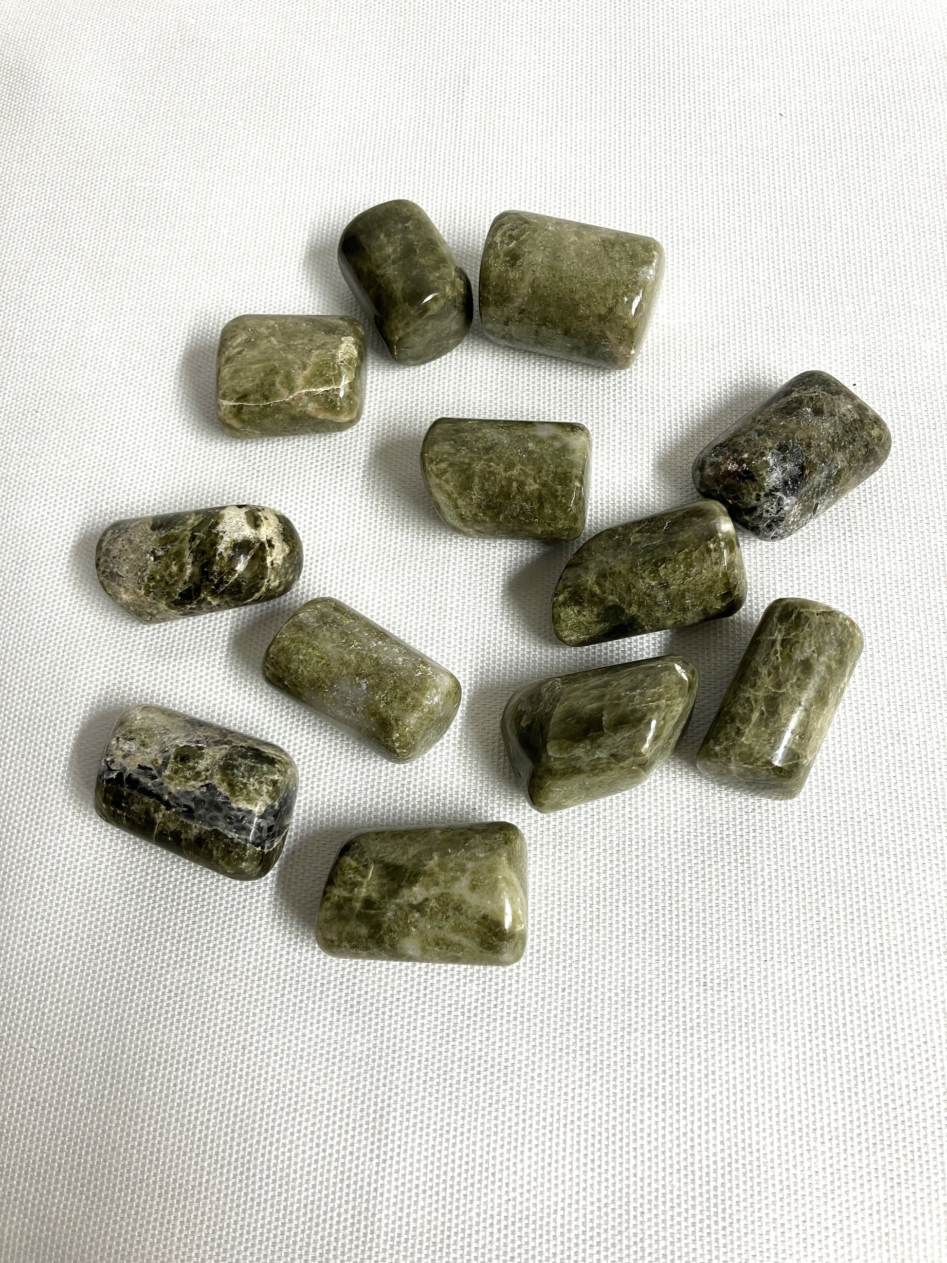 Back view of Vesuvianite Tumbled Crystals on a white fabric background