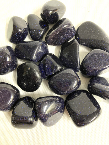 Blue Goldstone Crystals showing the sparkles within the stone on a white background