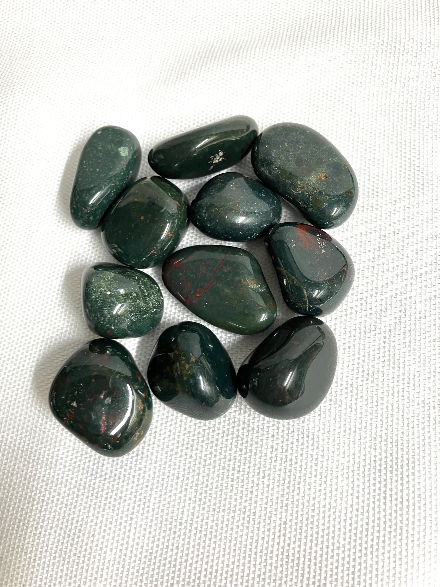 Tumbled Bloodstone Crystals on a white fabric background