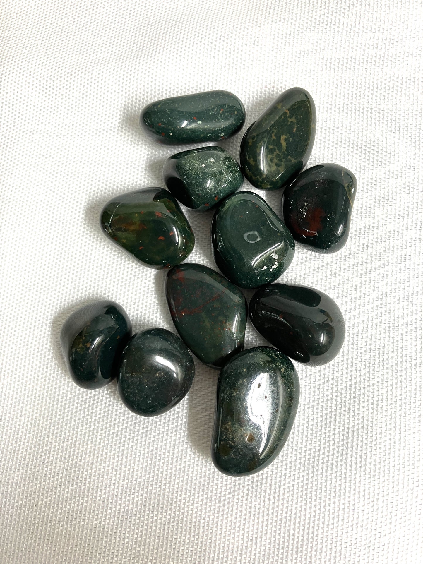 Collection of Bloodstone Crystals on a white fabric background