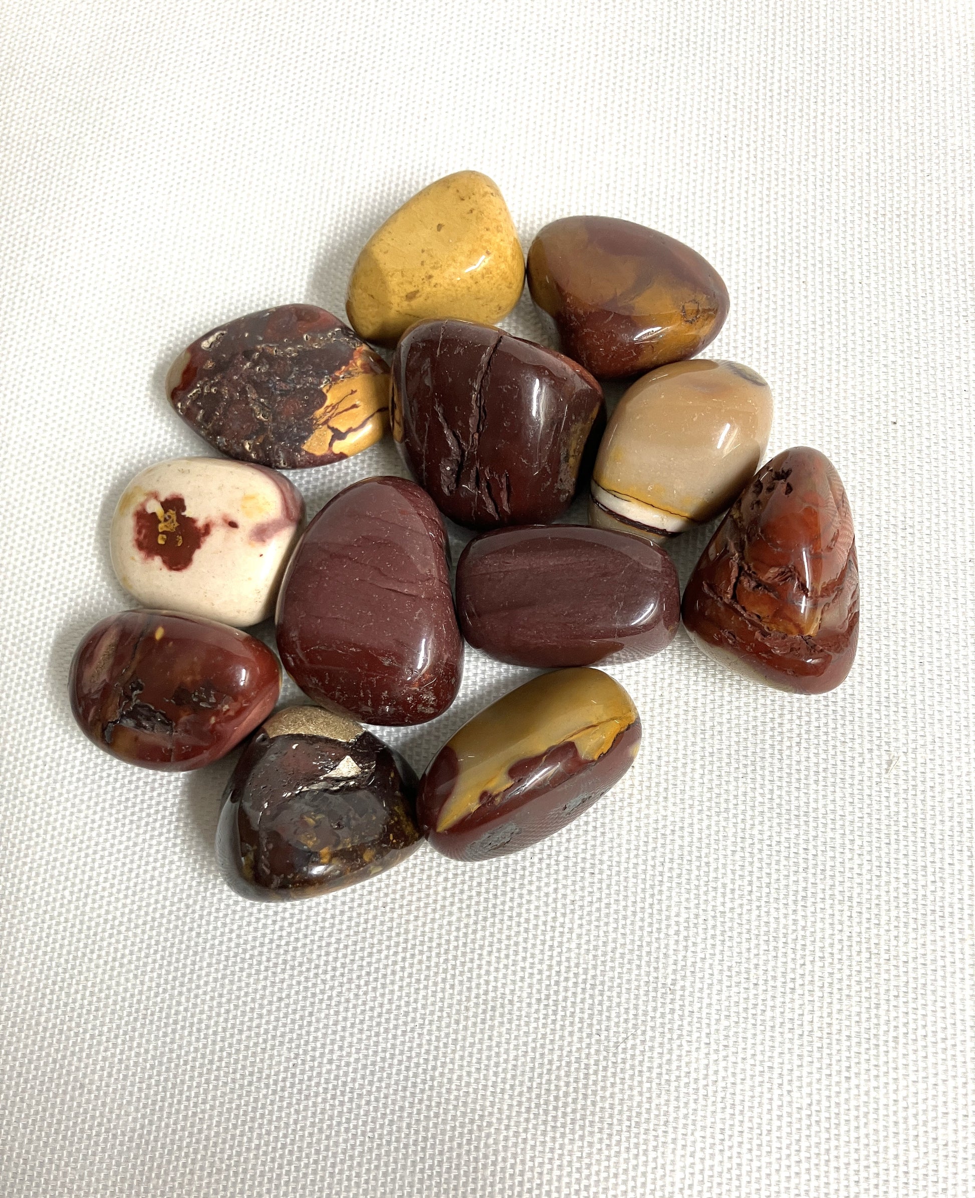 Collection of Mookaite Crystals on a white fabric background