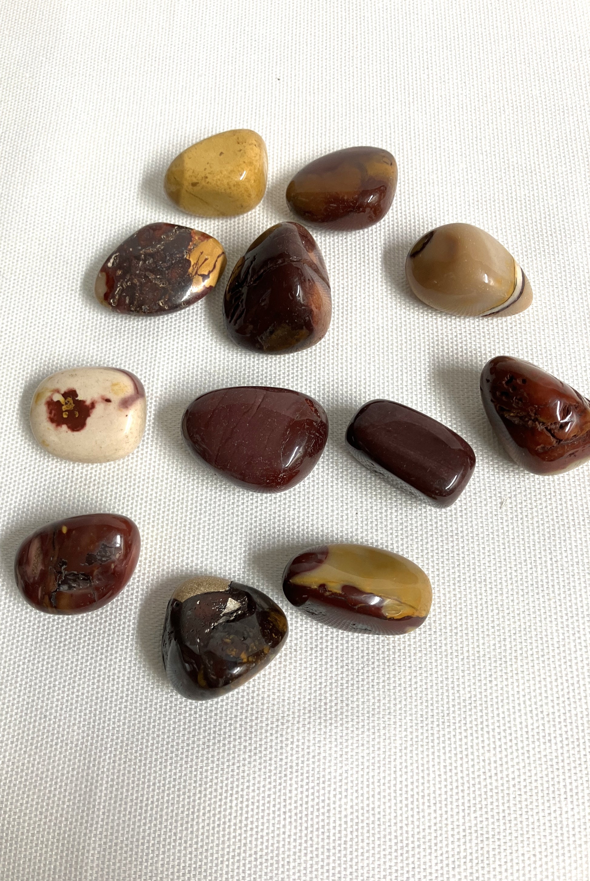 Collection of various shaped and sized Mookaite Crystals on a white background