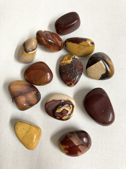 Group of Mookaite Crystals showing the variations on a textured white surface