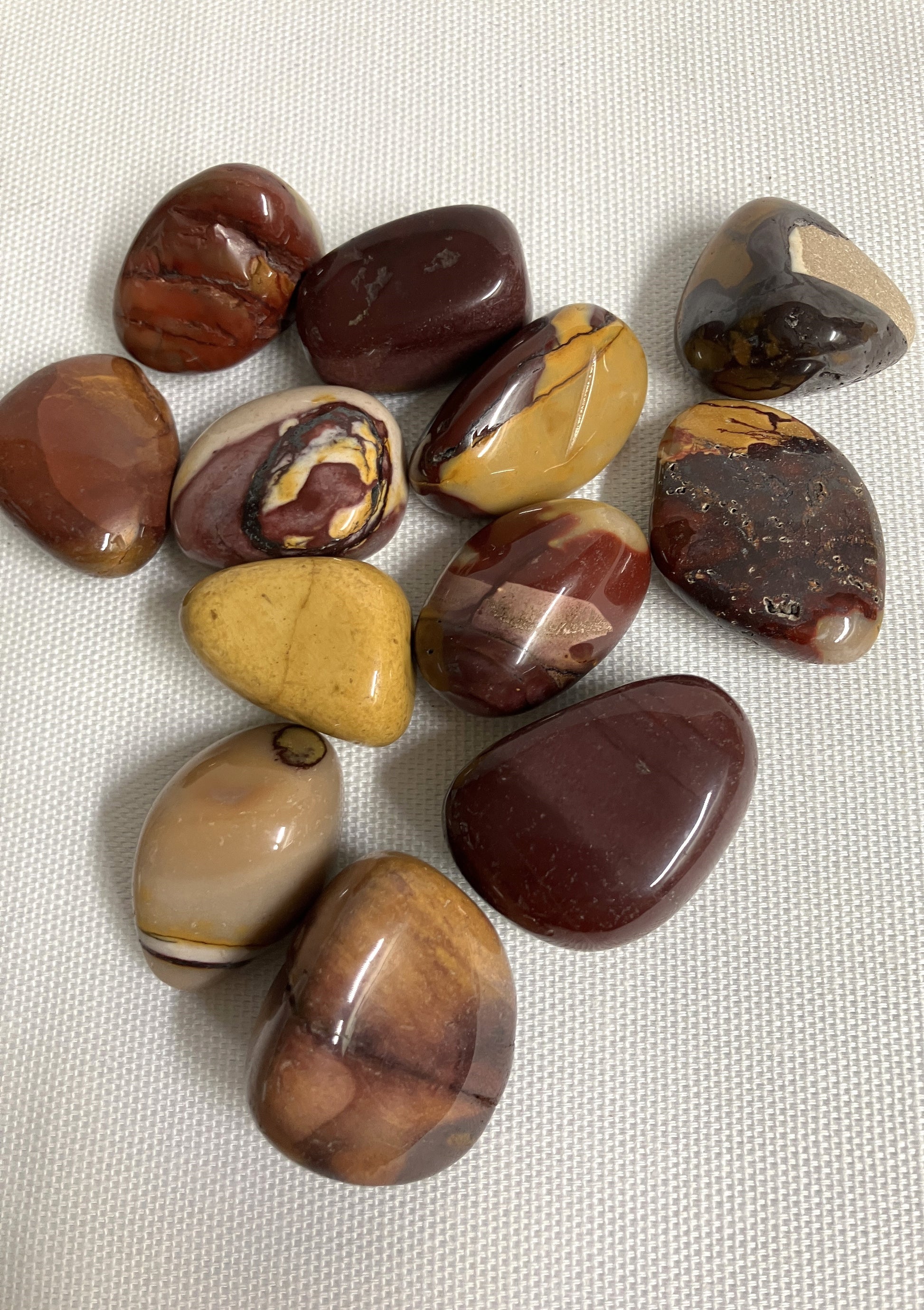 Collection of Mookaite Crystals on a textured fabric background