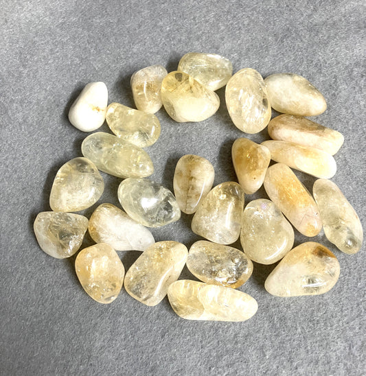 Collection of Citrine Tumbled Crystals on a gray background