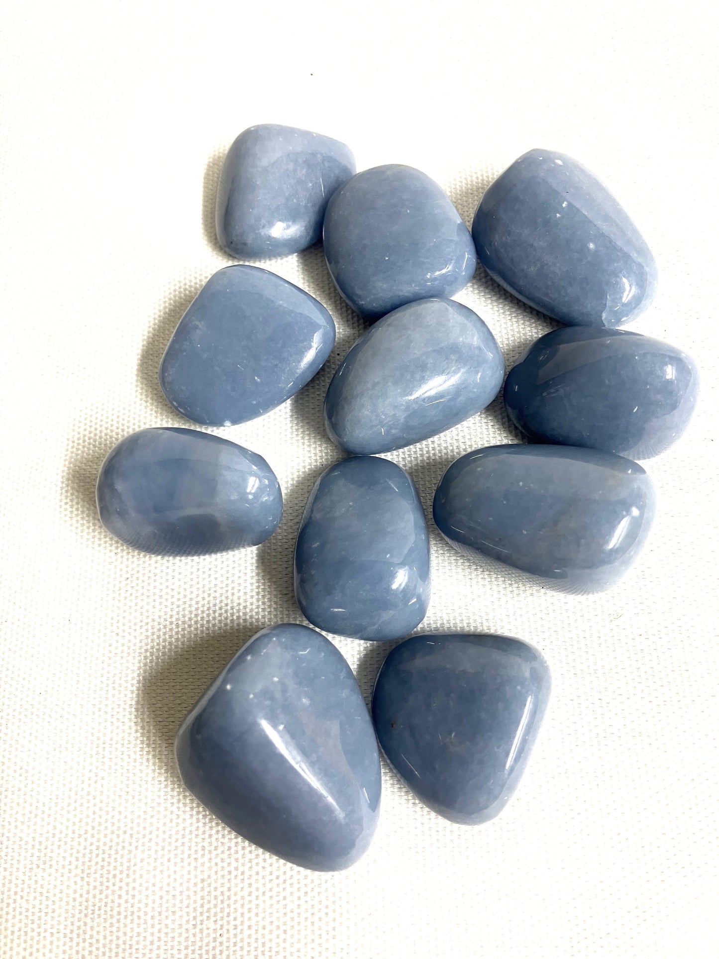 Front side of Angelite Crystals on a textured white surface