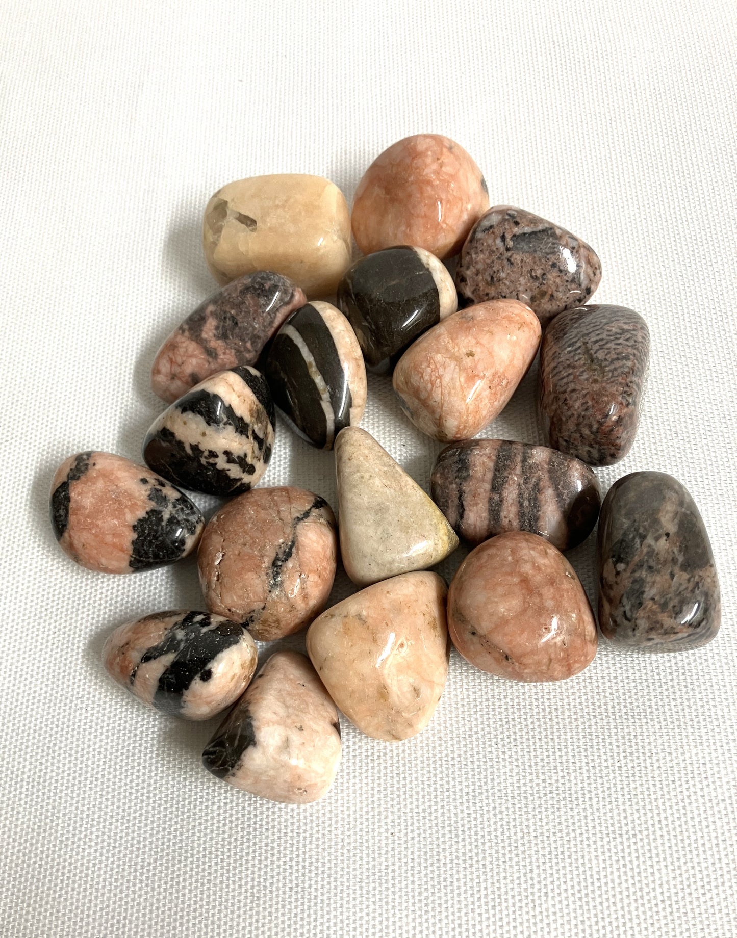 Front view of Pink Zebra Jasper Crystals on a white fabric background